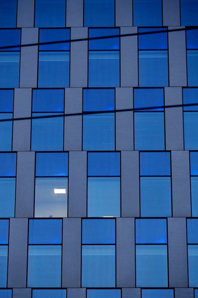 Symmetrical pattern of a modern glass façade with reflections.